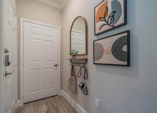 a hallway with a white door and a mirror on the wall