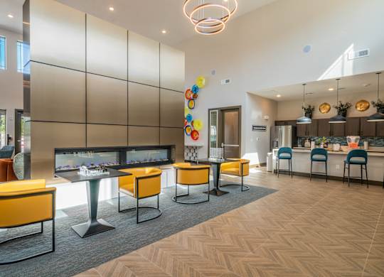 a communal area with tables and chairs and a fireplace