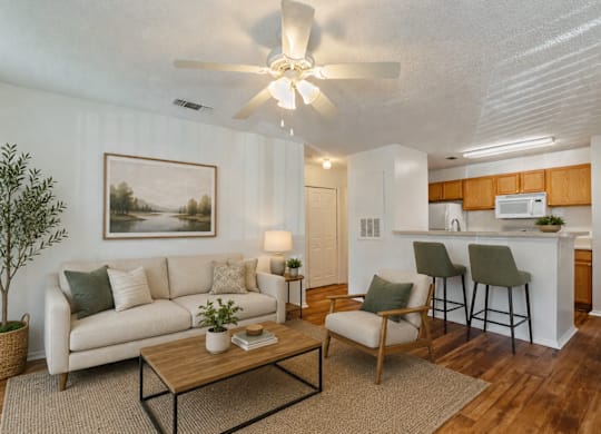 A living room with a white couch, a coffee table, and a painting on the wall.