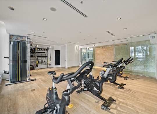 two treadmills in a gym with a glass wall and a yoga studio