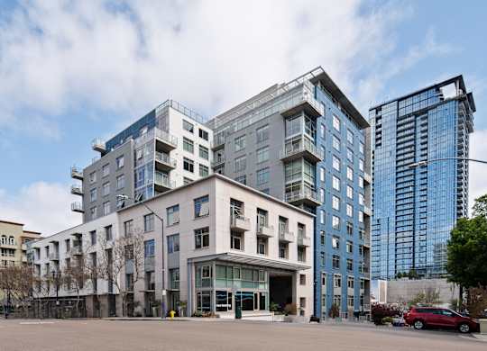 a large white building on a city street with tall buildings