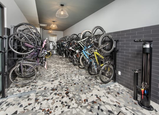 a row of bikes parked in a room with black tiles