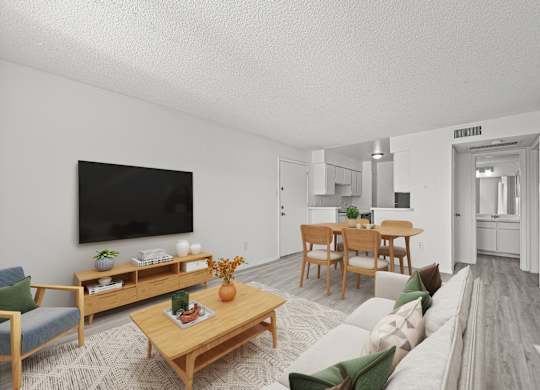A living room with a couch, chairs, a coffee table, and a television.
