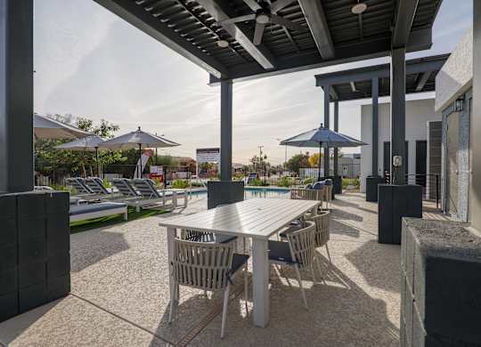 A patio with a table and chairs under a roof.