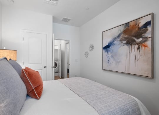 a bedroom with a large bed and a painting on the wall