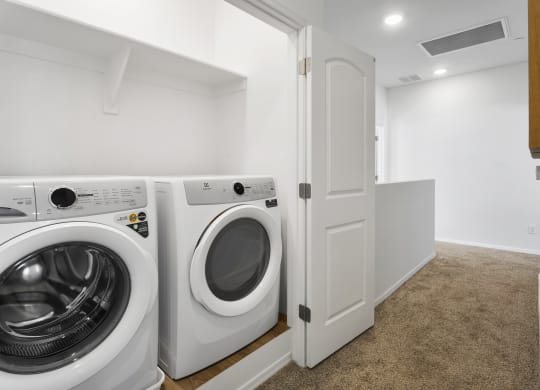 a washer and dryer in a laundry room with a white door