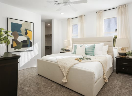 a bedroom with a white bed and a painting on the wall