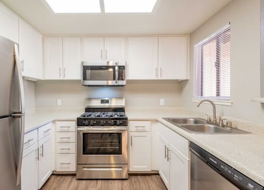 A kitchen with white cabinets and stainless steel appliances.
