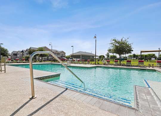 A swimming pool with a slide and sun loungers.