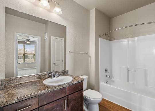 A bathroom with a sink, toilet, and bathtub.