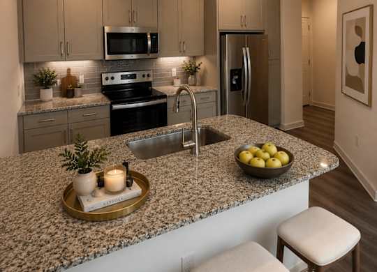 A kitchen with granite countertops and a bowl of lemons on it.