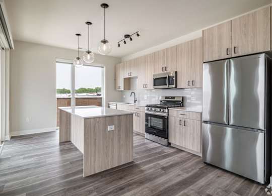 A modern kitchen with a large island and stainless steel appliances.