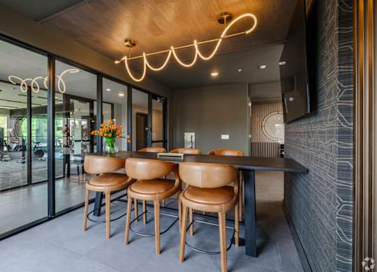 A modern dining area with a wooden table and chairs.