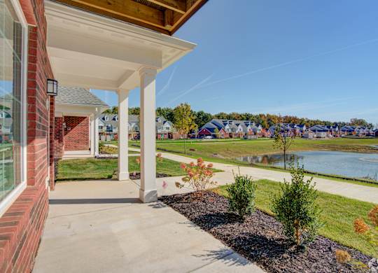 the view from the front porch of a house with a river in the background
