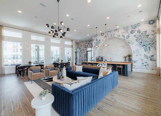 A living room with a blue sofa and wooden floors.