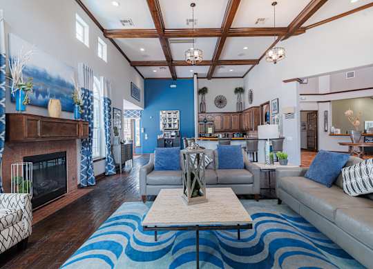 A living room with a fireplace and a blue rug.