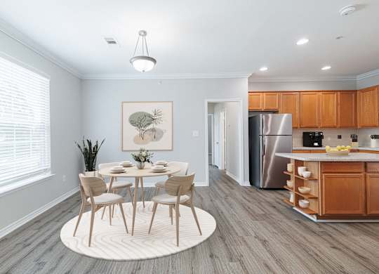 A dining room with a table set for four and a kitchen in the background.