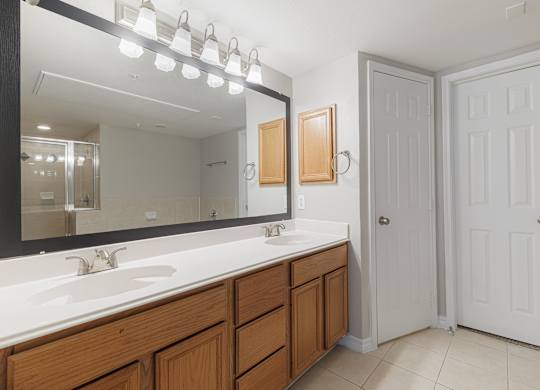 A bathroom with a sink, mirror, and two doors.