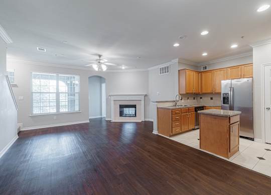 A spacious kitchen with wooden cabinets and a refrigerator.