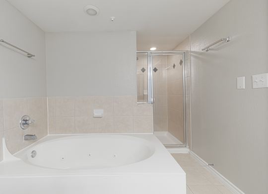A white bathroom with a large tub and a walk-in shower.