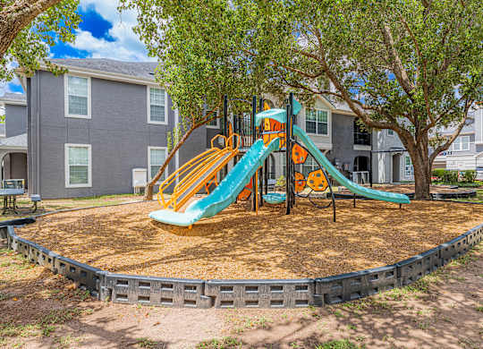 A playground with a green and yellow slide.