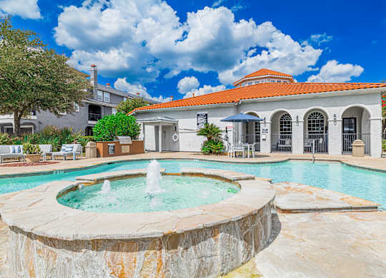 A pool with a fountain in the middle of it.