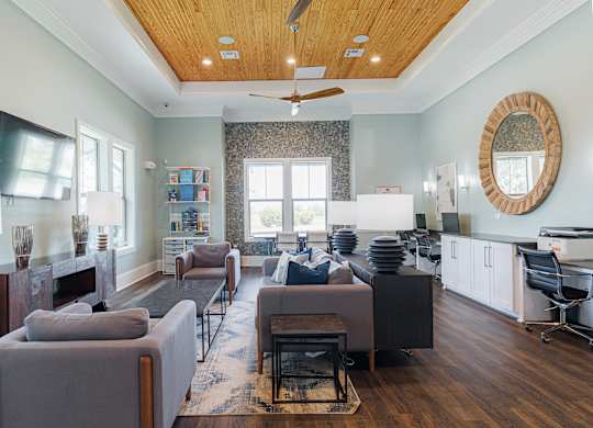A living room with a grey couch and a wooden floor.