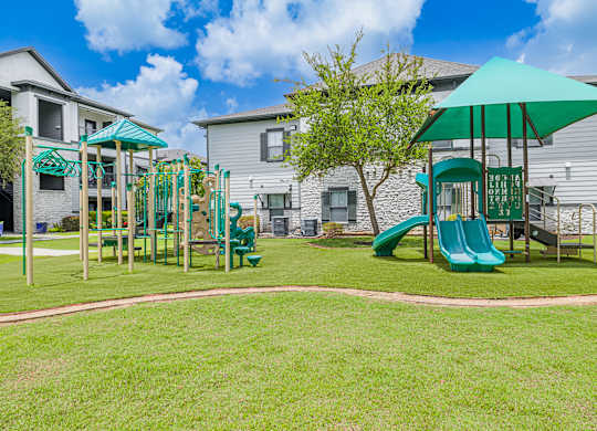 A playground with a green slide and a green umbrella.