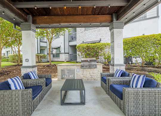 A patio with a table and chairs under a roof.