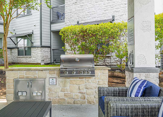 A stone wall with a grill on top of it.
