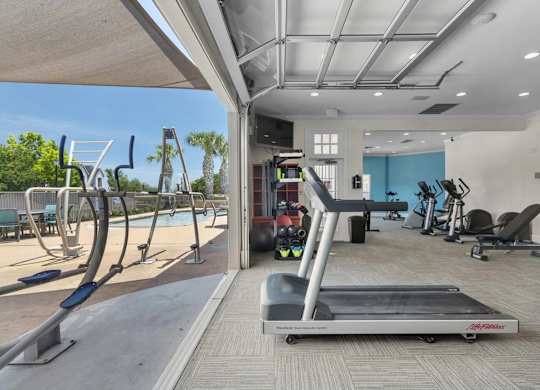 A treadmill is in the middle of a room with exercise equipment.