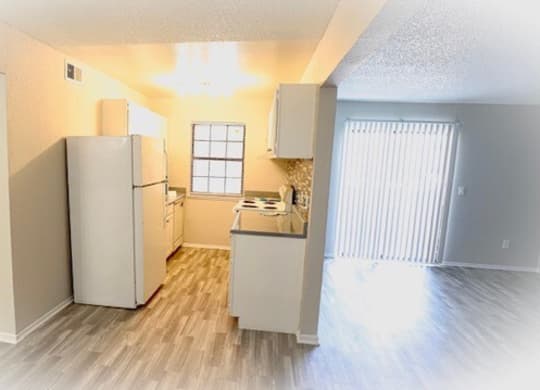 an empty kitchen with a refrigerator and a sink