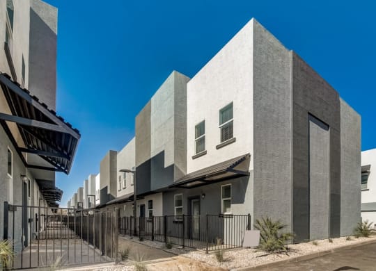 modern town homes with a gate and a street in front of them
