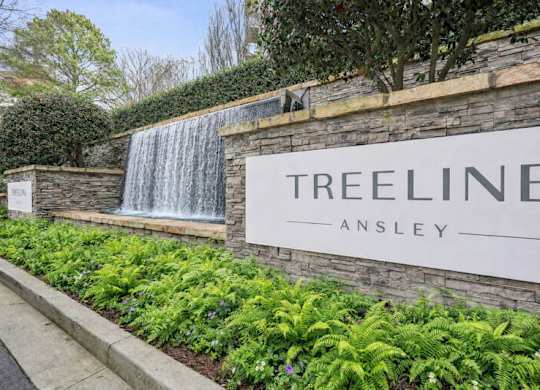 A wall with a waterfall and a sign that says Treeline Ansley.