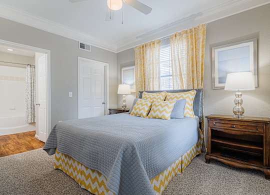 a bedroom with a large bed and yellow curtains