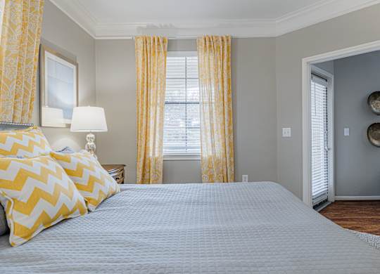 a bedroom with a large bed and yellow curtains