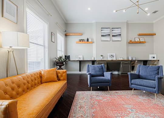 a living room with a yellow couch and two blue chairs