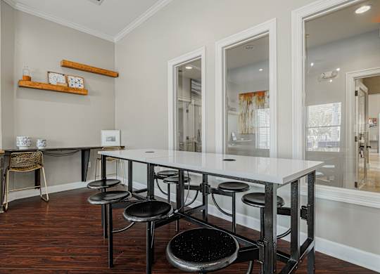 A dining room with a white table and black stools.