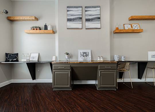 A room with a desk and chairs with a grey and black theme.