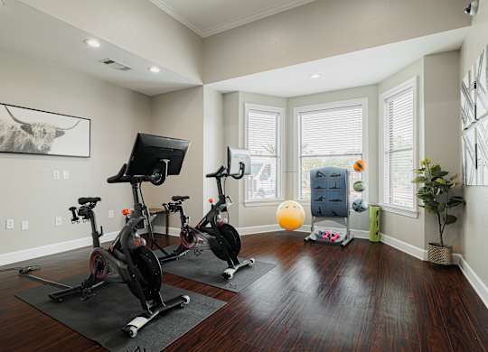 A room with a wooden floor and exercise equipment.