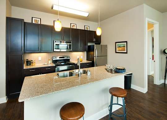 A kitchen with a counter and bar stools.