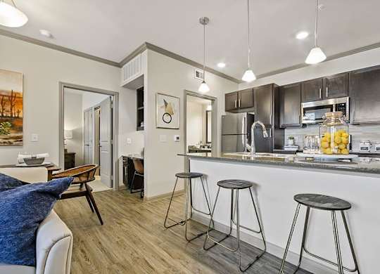 A kitchen with a bar stool in front of it.