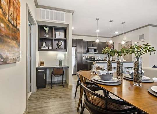 A modern kitchen with a dining table set for two.