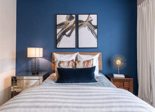a bedroom with a bed and a large wall