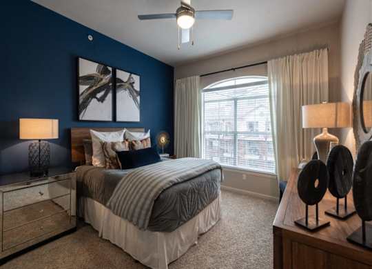 a bedroom with blue walls and a bed and a window