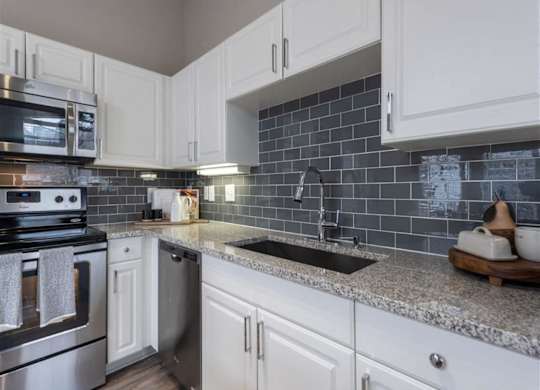 a kitchen with white cabinets and a sink
