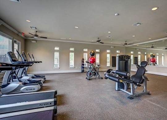 A gym with treadmills, exercise bikes, and weight machines.