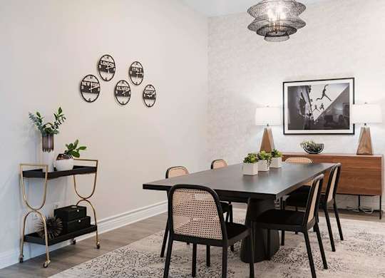 A dining room with a black table and chairs.