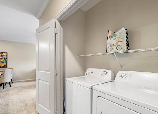 A white washing machine and dryer in a laundry room.