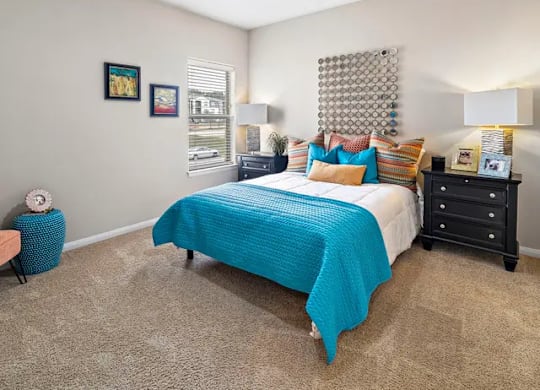 A bedroom with a bed, dresser, and ceiling fan.